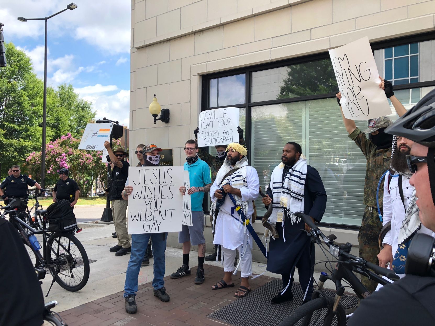 Protesters stand aside the Pridefest parade